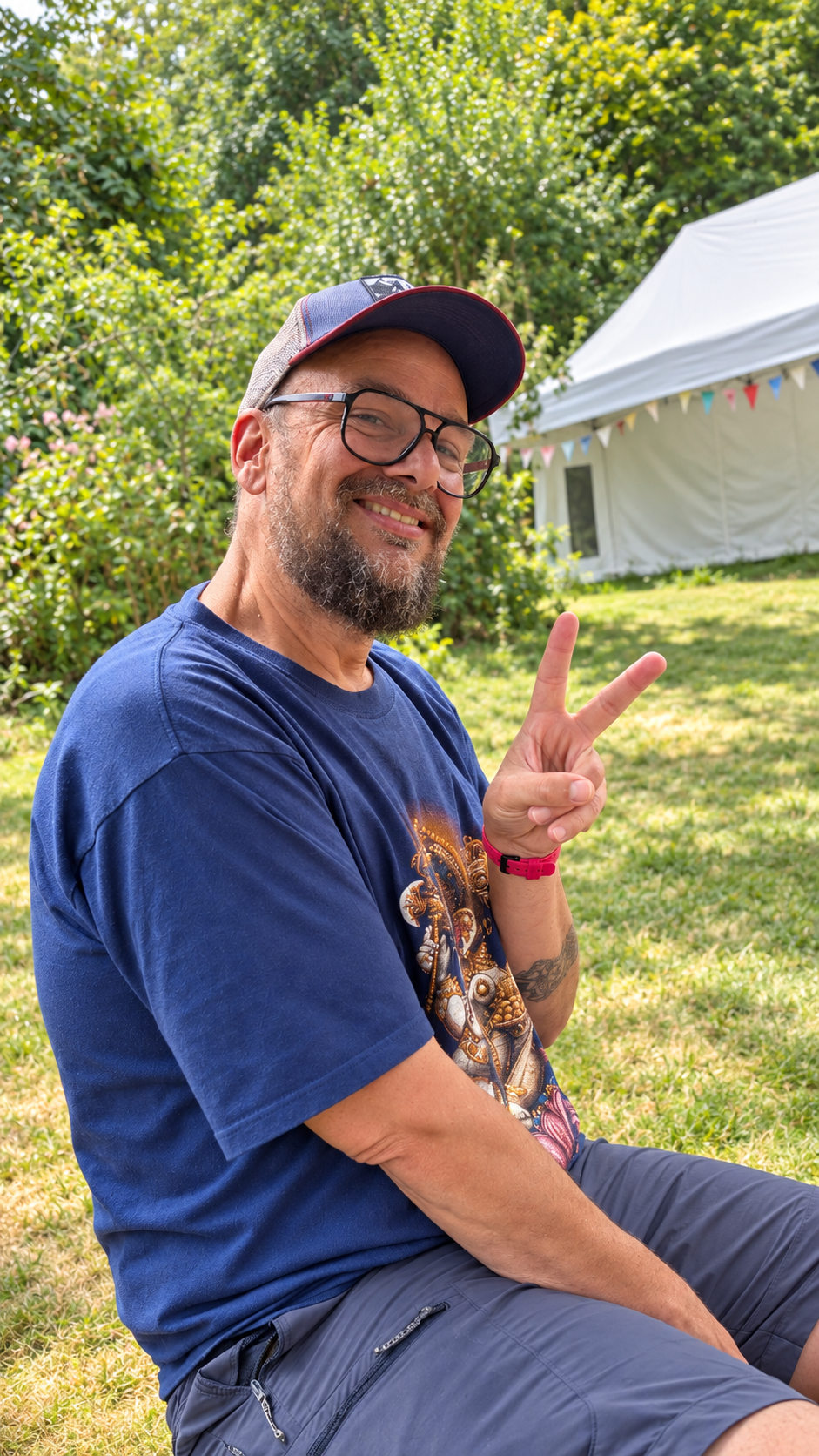 Jonathan smiling outdoors and holding up a peace sign